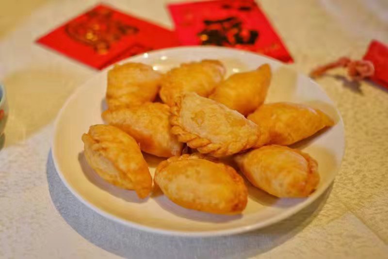Savurând delicioase găluște crocante de patiserie pentru a întâmpina Anul Nou Chinezesc